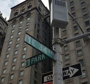 Low angle view of road sign against buildings in city