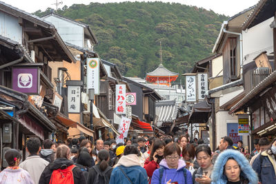 People on street amidst buildings in city