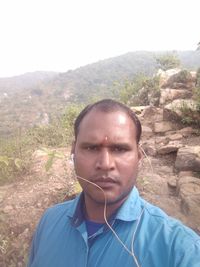 Portrait of young man standing on mountain