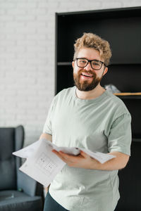 Portrait of young man standing against wall