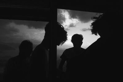 Silhouette of people against cloudy sky