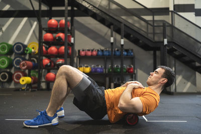 Sportsman practicing with pilates rolls in gym