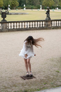 Full length of a girl standing against stone wall