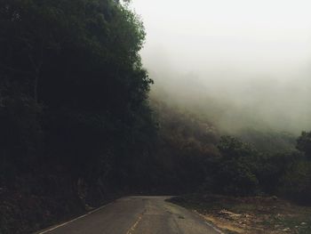 Road amidst trees against sky