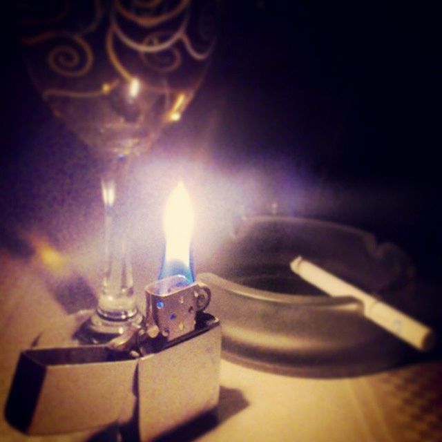 indoors, burning, flame, candle, heat - temperature, fire - natural phenomenon, illuminated, lit, glowing, close-up, still life, candlelight, table, lighting equipment, tea light, bottle, selective focus, focus on foreground, light - natural phenomenon, no people