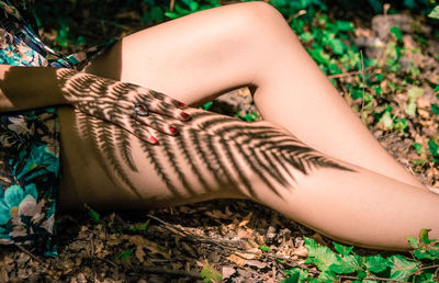 Low section of woman lying on land