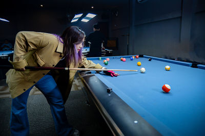 Midsection of man playing pool