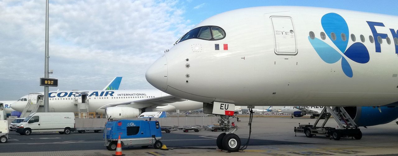 air vehicle, airplane, mode of transportation, transportation, airport, travel, airport runway, sky, day, commercial airplane, stationary, nature, outdoors, cloud - sky, aerospace industry, public transportation, window, passenger boarding bridge, no people, sunlight, arrival