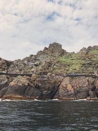 Rock formations by sea against sky