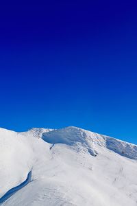 Scenic view of snowcapped mountains against clear blue sky