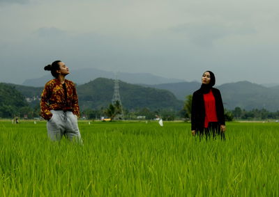 Women standing on field against sky