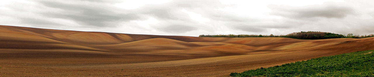 View of desert against cloudy sky