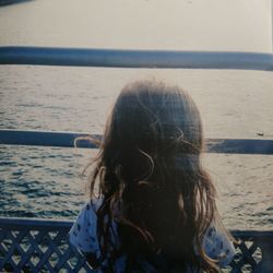 Rear view of woman in sea against sky