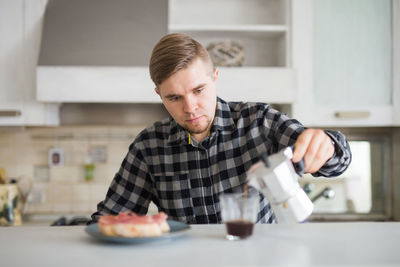 Portrait of boy eating food at home