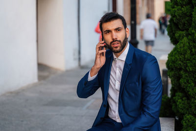 Young man using mobile phone outdoors