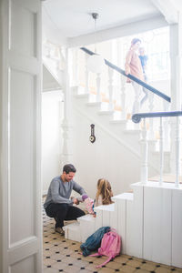 Father preparing girl for school