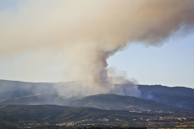 Smoke emitting from volcanic mountain against sky