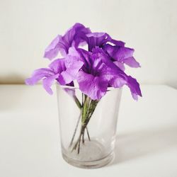 Close-up of purple flower in glass vase on table