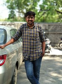 Portrait of smiling man standing in car