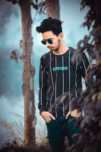 Full length of young man wearing sunglasses standing on land