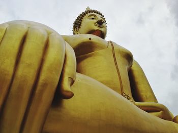 Low angle view of statue against temple against sky