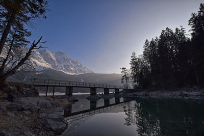 Bridge over river by mountain against sky