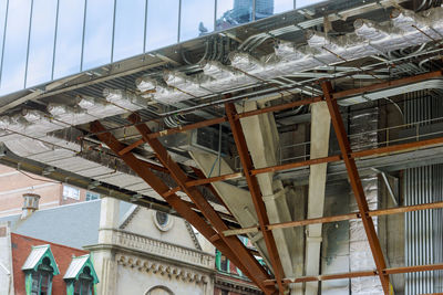 Low angle view of broken glass building against sky