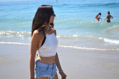 Full length of woman standing on beach against sky