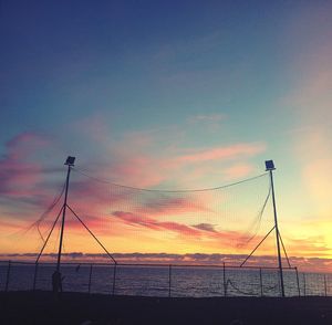 Silhouette man on beach against sky during sunset