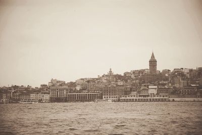 Panoramic view of sea and cityscape against clear sky