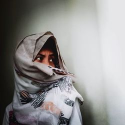 Portrait of woman standing against wall