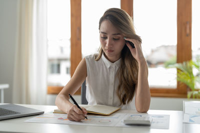 Young woman using laptop at office