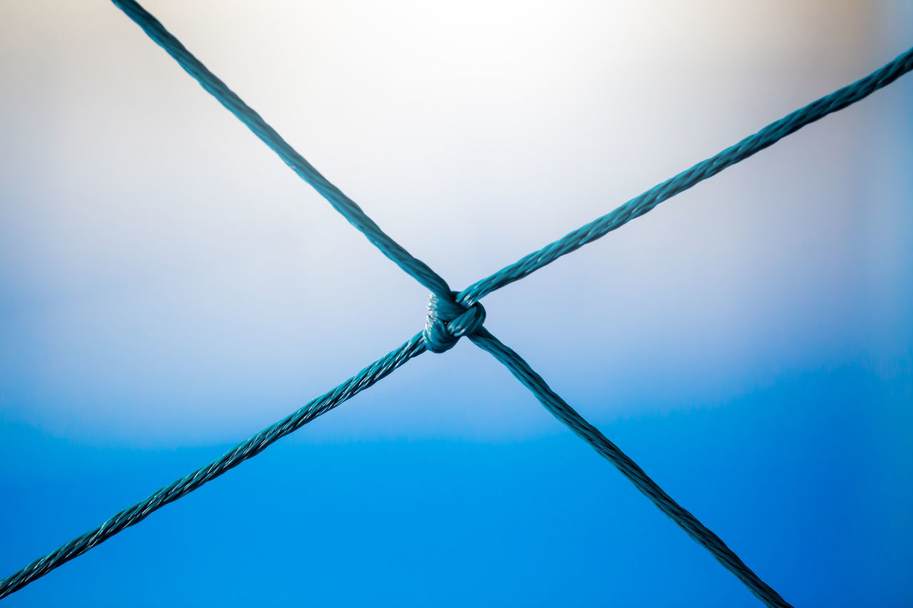 LOW ANGLE VIEW OF METAL FENCE AGAINST BLUE SKY