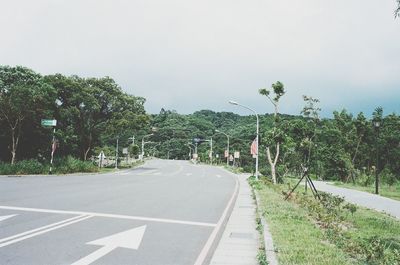 Road amidst trees against sky