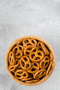 Traditional salty mini pretzels in wooden bowl on gray backround. top view, copy space