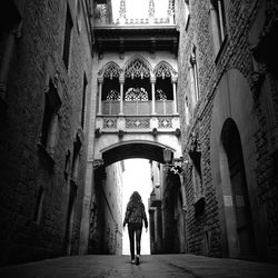 Full length rear view of people walking in tunnel