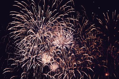 Low angle view of firework display against sky at night