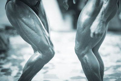 Midsection of muscular men standing in gym