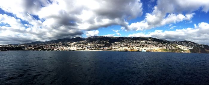 Panoramic view of sea and snowcapped mountains against sky