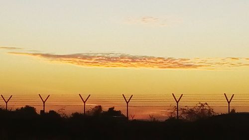 Windmills on landscape at sunset