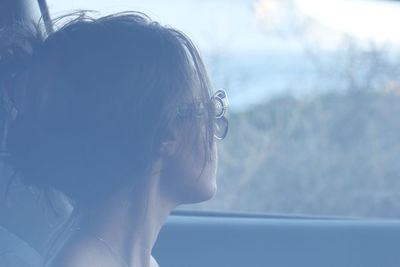 Close-up of woman wearing sunglasses in car