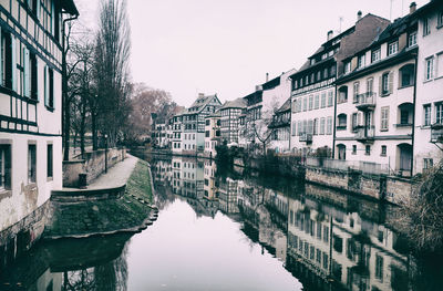 Canal amidst buildings in city against sky