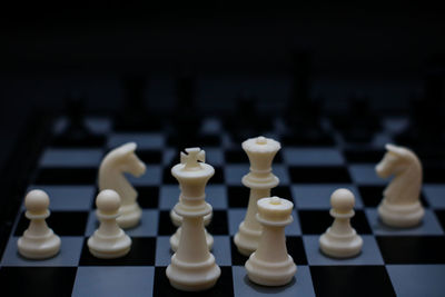 High angle view of chess pieces on board against black background