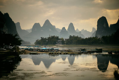Scenic view of river and mountains against sky