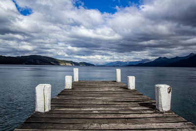 Wooden pier over sea against sky