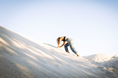 Full length of person on snowcapped mountain against clear sky