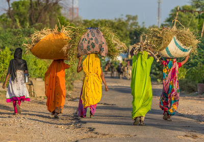 Rear view of people walking on multi colored umbrella