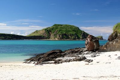 Scenic view of rocks on beach against sky