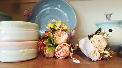 Close-up roses with crockery on table
