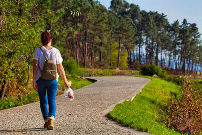 Girl walking with a bag of trash after cleaning